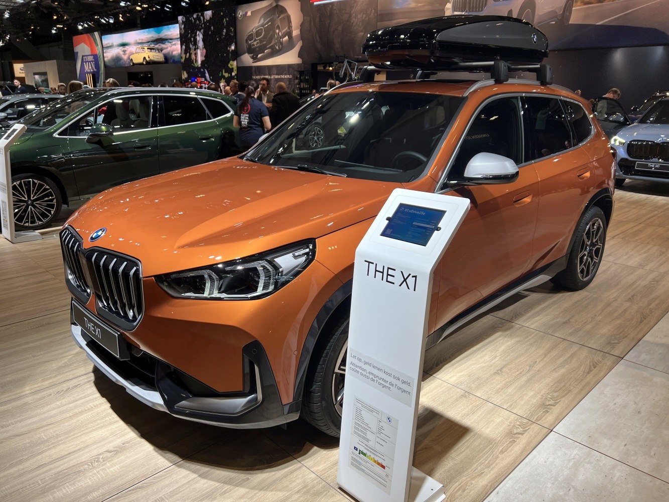 Front side view of SUV with roof box and modern grille