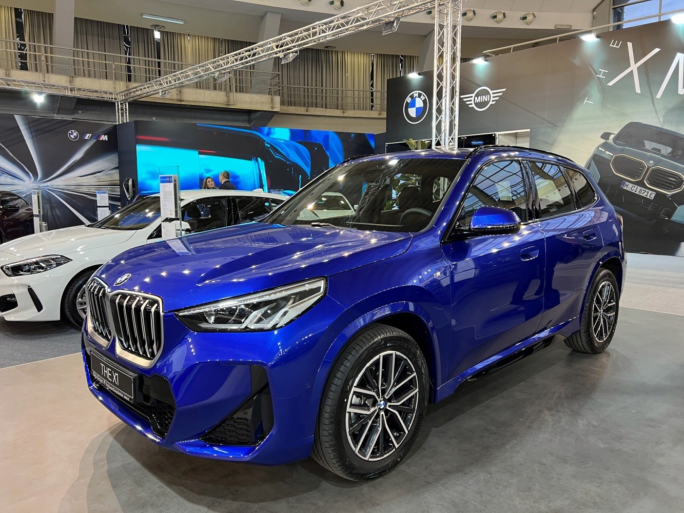 Front 3/4 exterior view of blue luxury compact SUV with alloy wheels