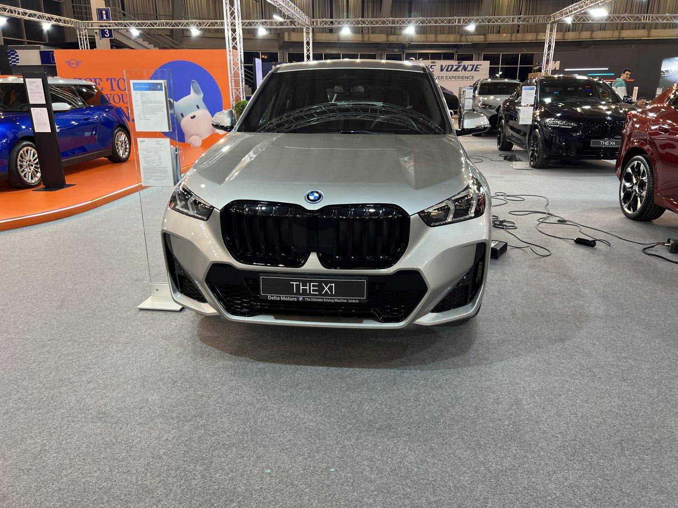 Front of vehicle with large black kidney grille and sharp LED headlights