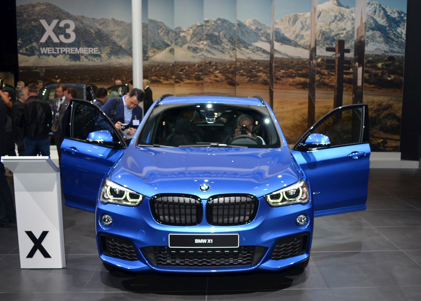 Front view of SUV with open doors and illuminated headlights