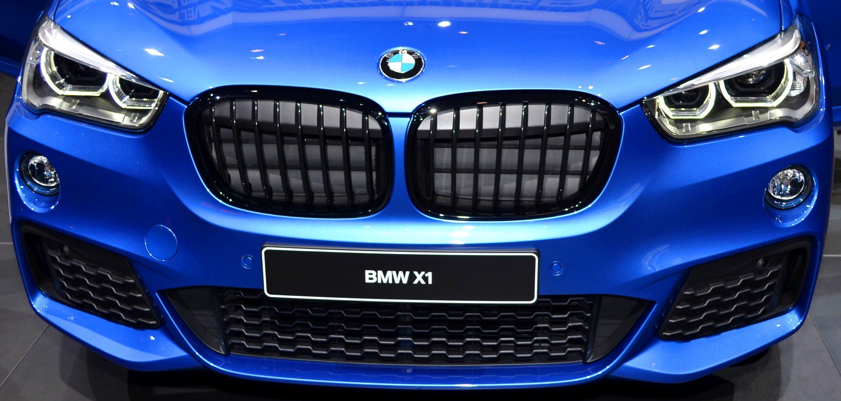 Front grille with kidney design and LED headlights of a blue vehicle