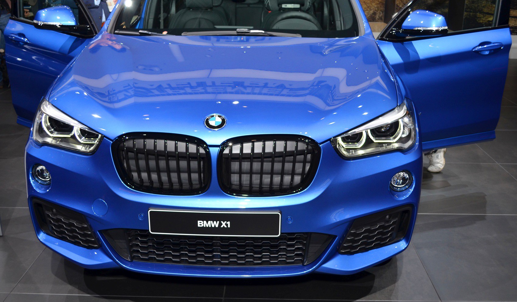 Dual LED headlights and black kidney grille on a sleek blue vehicle front