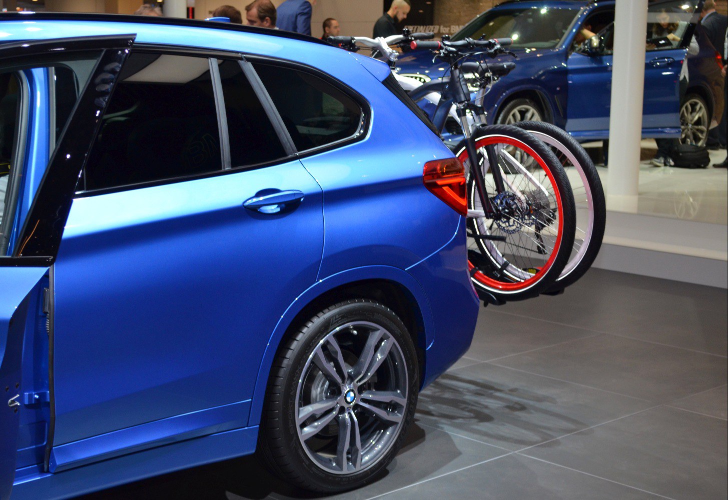 Rear side of blue vehicle with open door and bike rack carrying bicycles