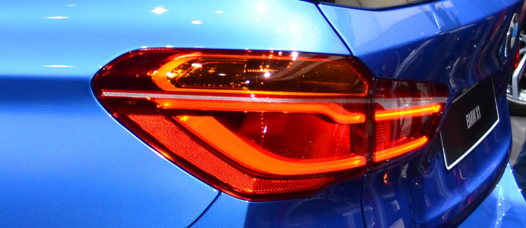 Close-up of rear tail light with LED design on blue hatchback.