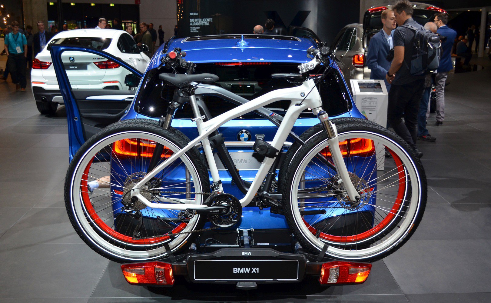Rear view of blue SUV with rear bike rack and mounted white bicycle