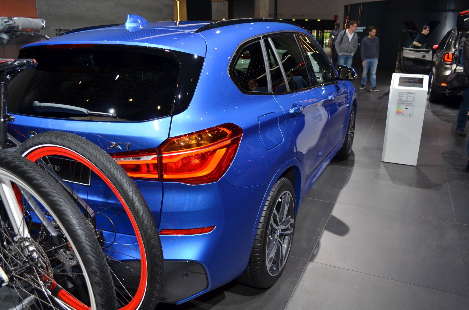 Rear side of blue SUV with taillight and bicycle mounted on hatchback