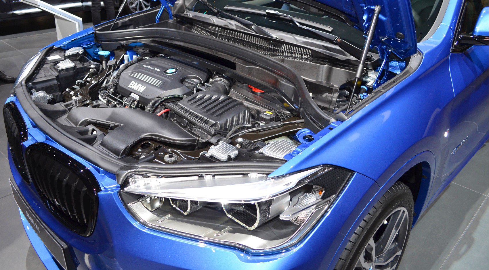 Engine bay with visible BMW engine and front LED headlight