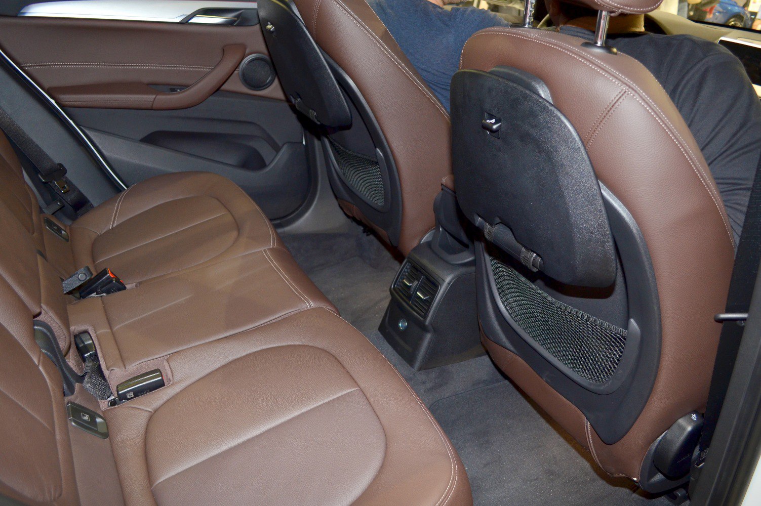 Rear interior with brown leather seats and air vents