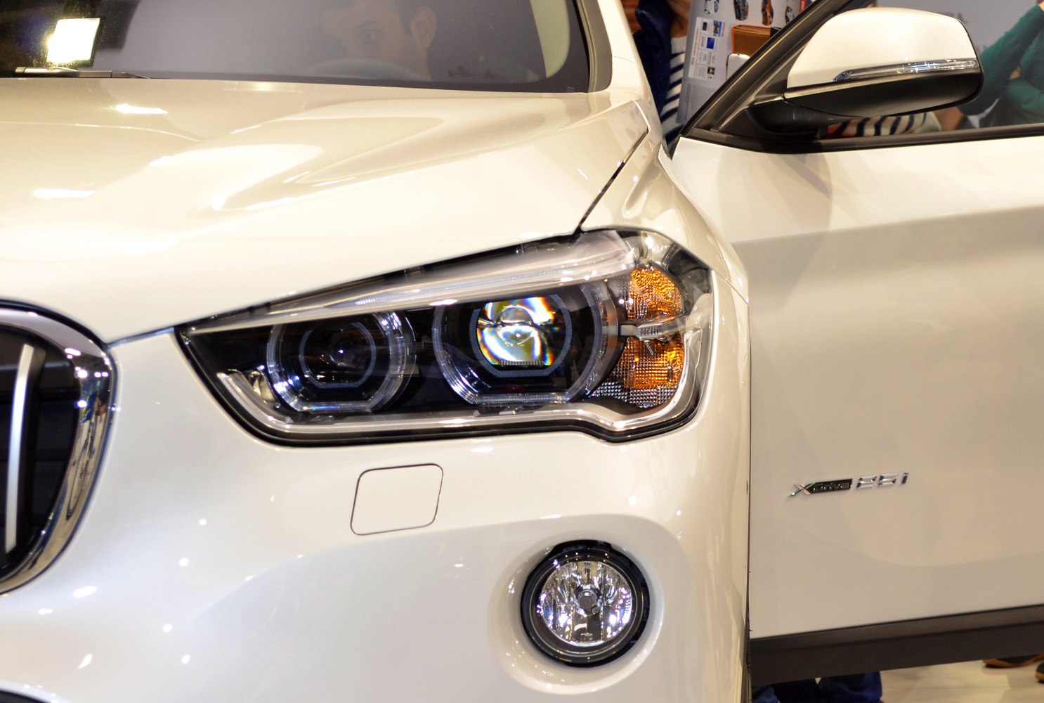 Front headlight, fog light, and side mirror details of a vehicle