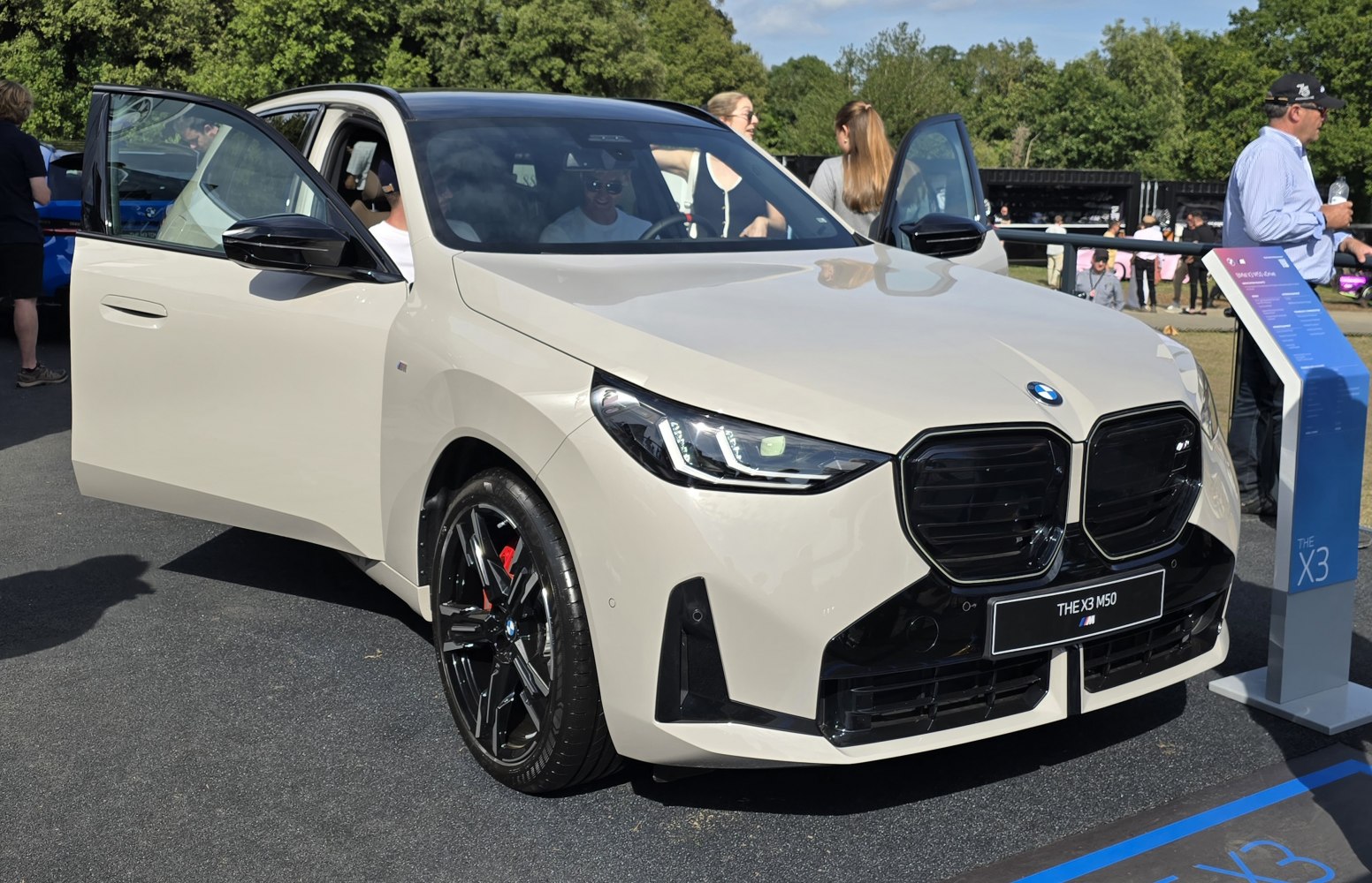 Front view with open doors, black kidney grille, and sporty wheels