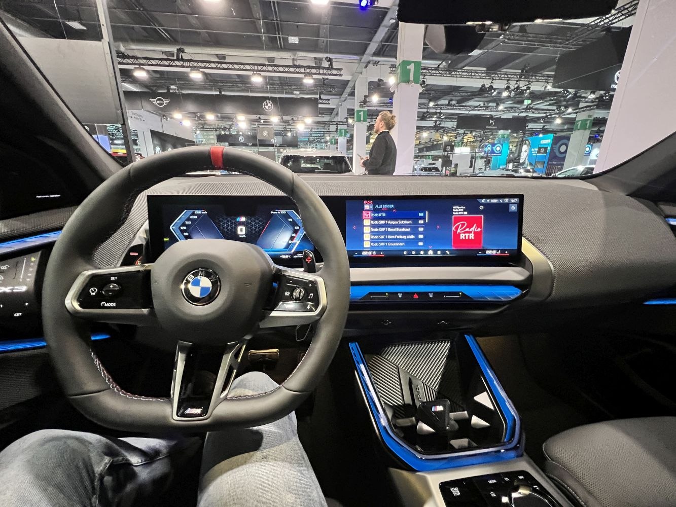 Modern digital dashboard and sporty steering wheel view with blue accent trim.