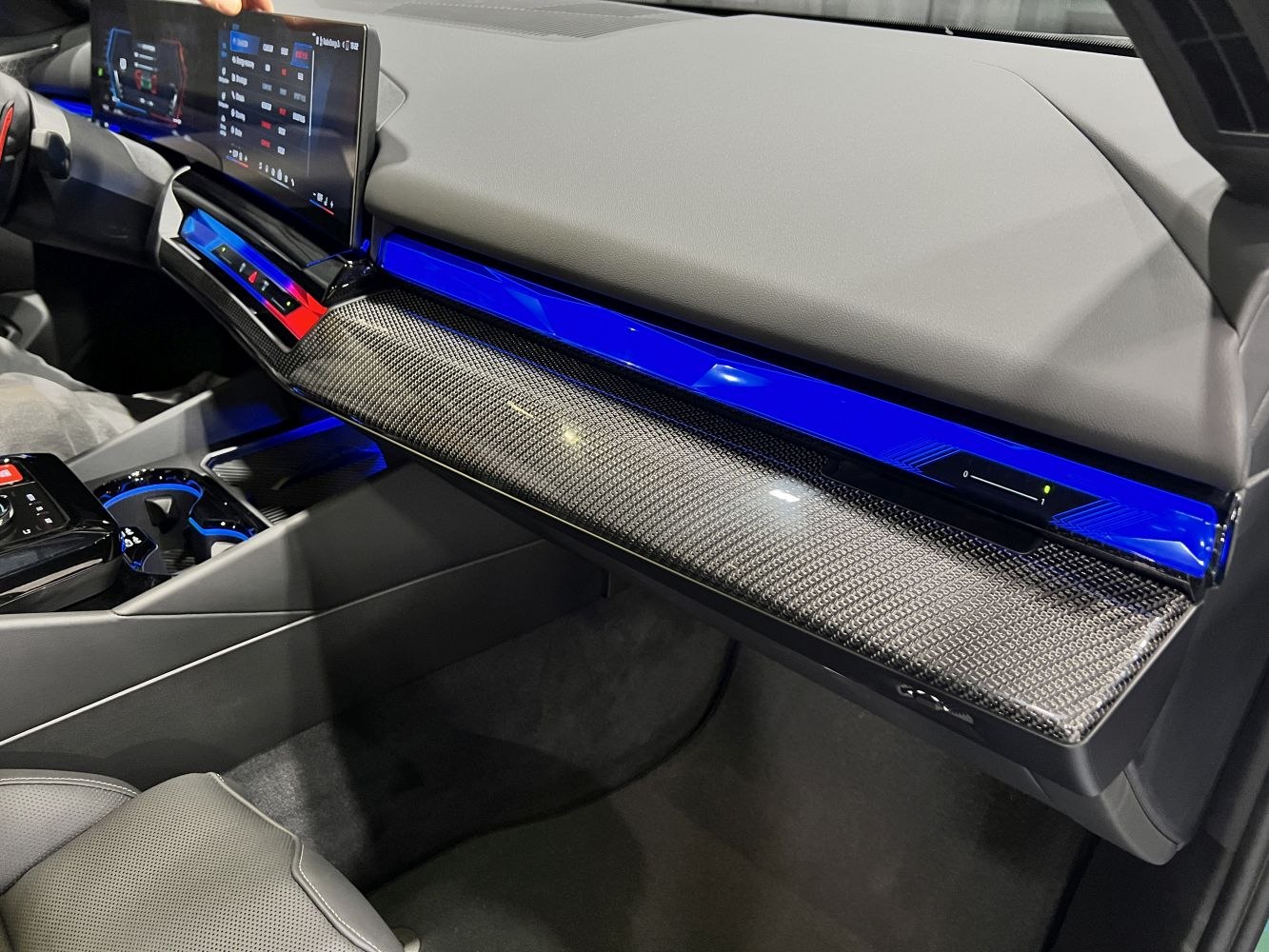 Interior dashboard with carbon fiber trim and blue ambient lighting