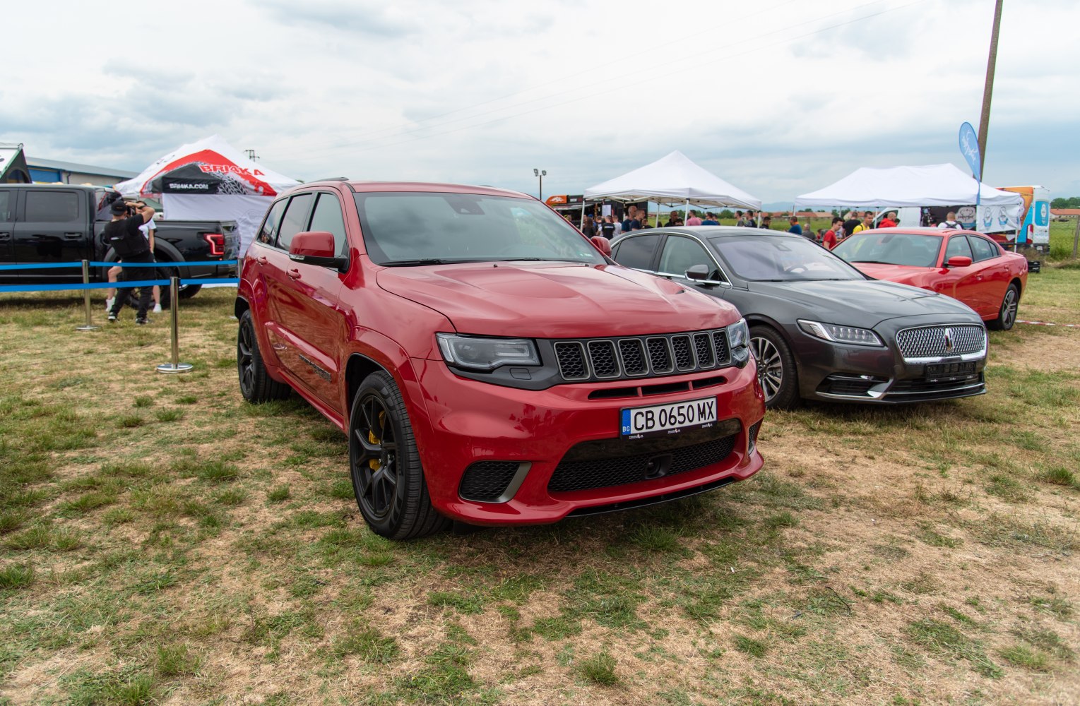 Red SUV with aggressive seven-slot grille and sporty front fascia