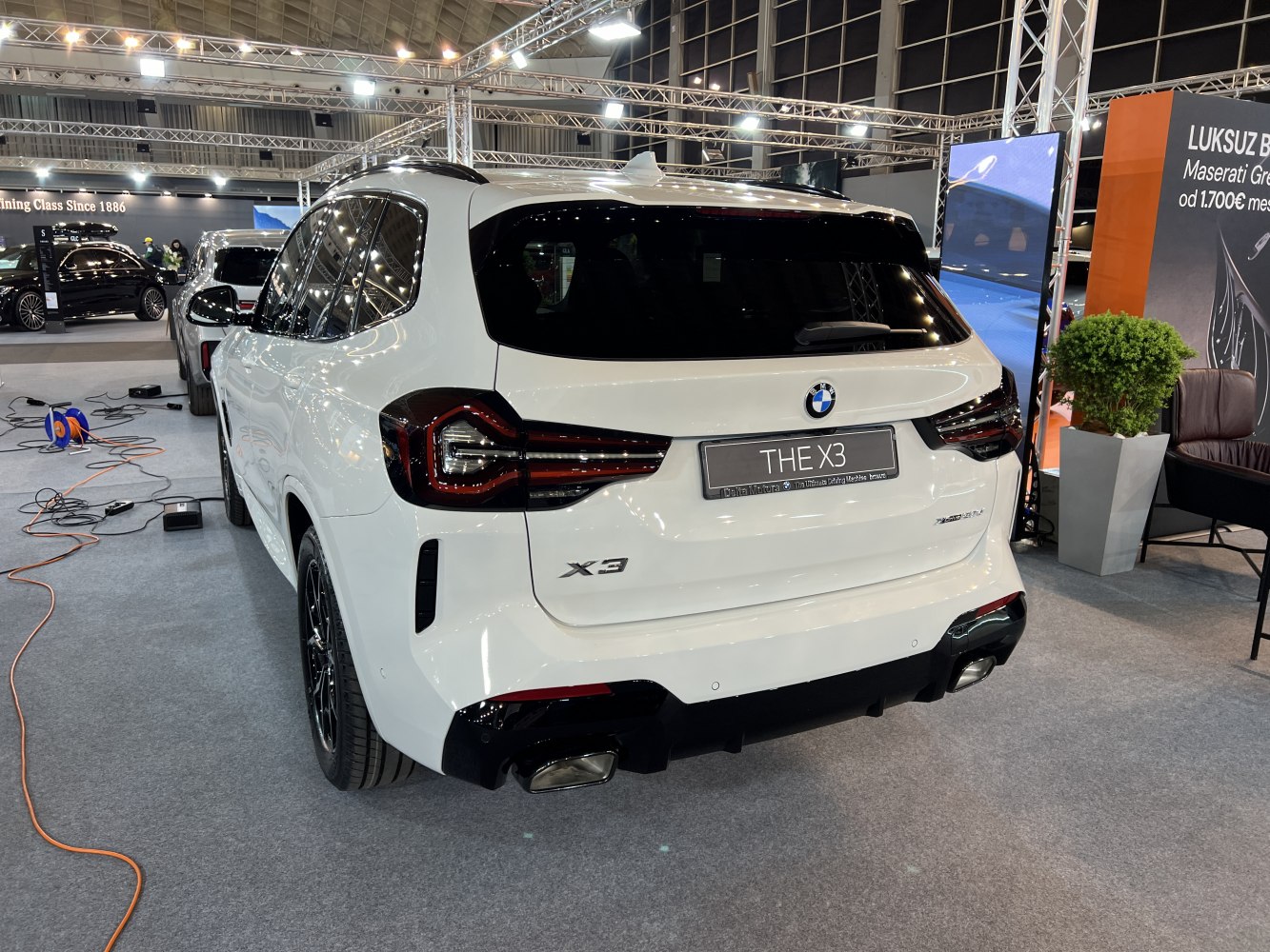 White luxury SUV rear, distinct taillights, dual exhaust