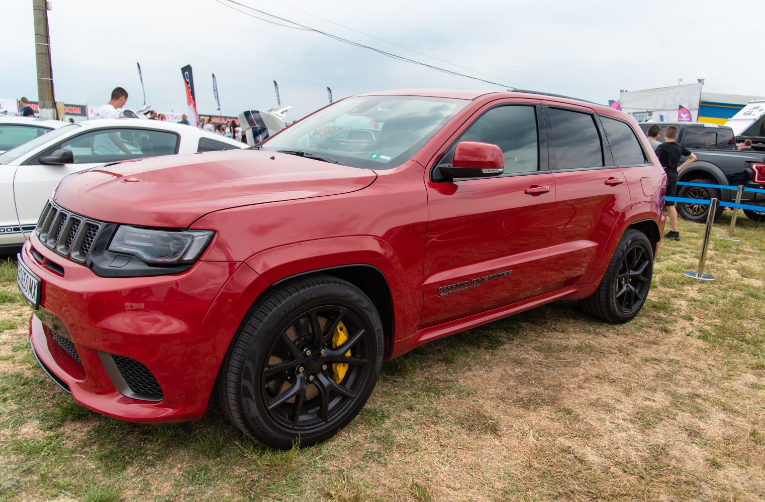Red SUV with black wheels and yellow brake calipers.