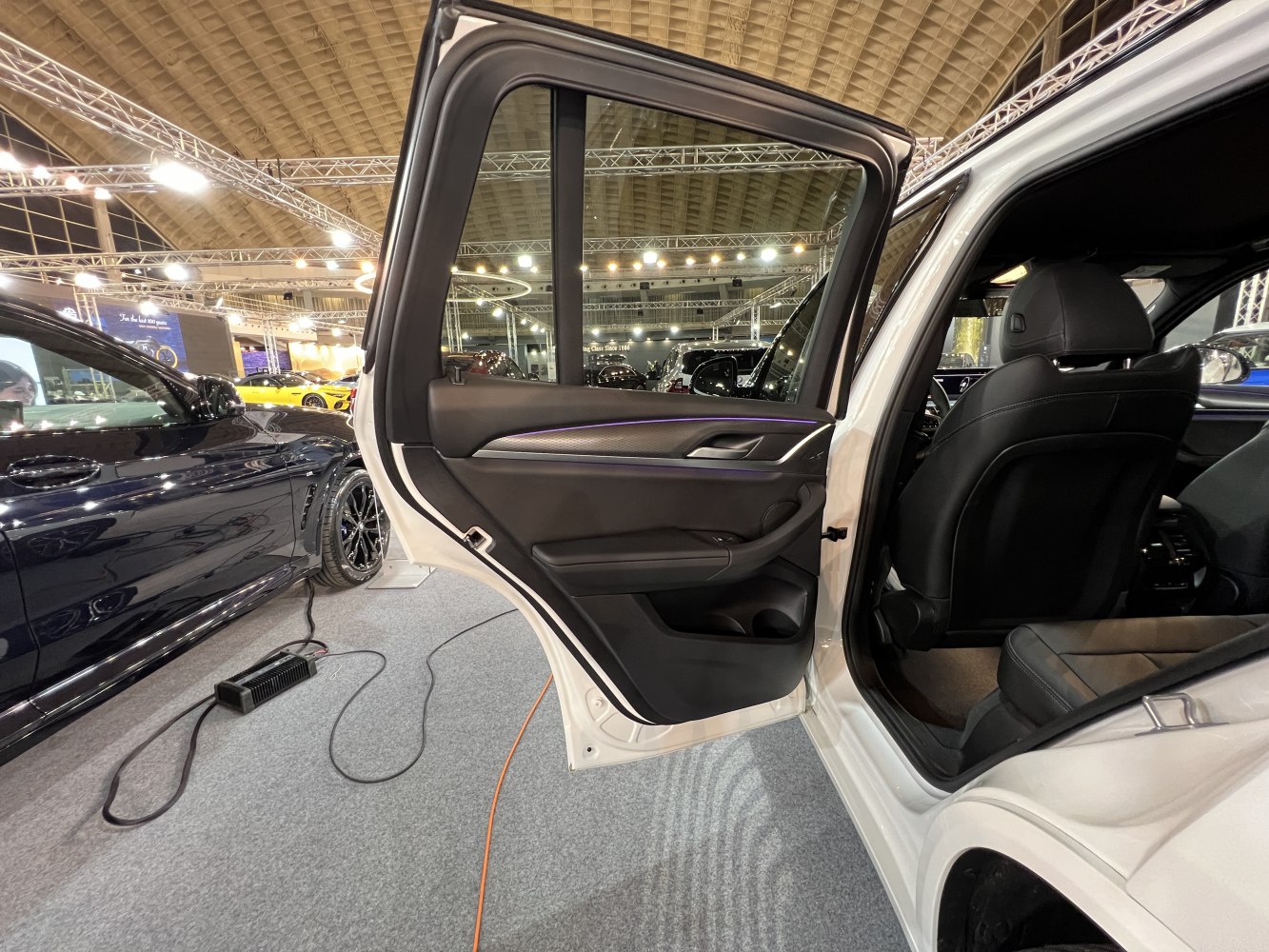 Rear door panel and black leather rear seats interior with ambient lighting