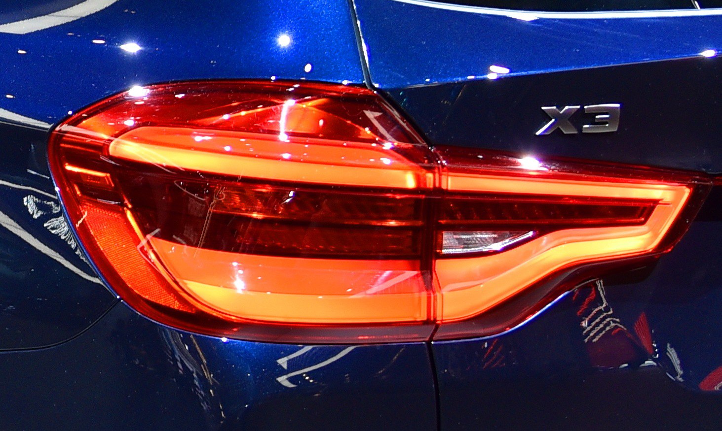 Close-up of LED tail light with sharp design and X3 badge