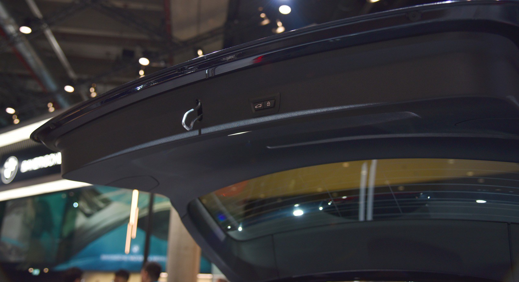Close-up of vehicle tailgate interior with electric closing button and latch