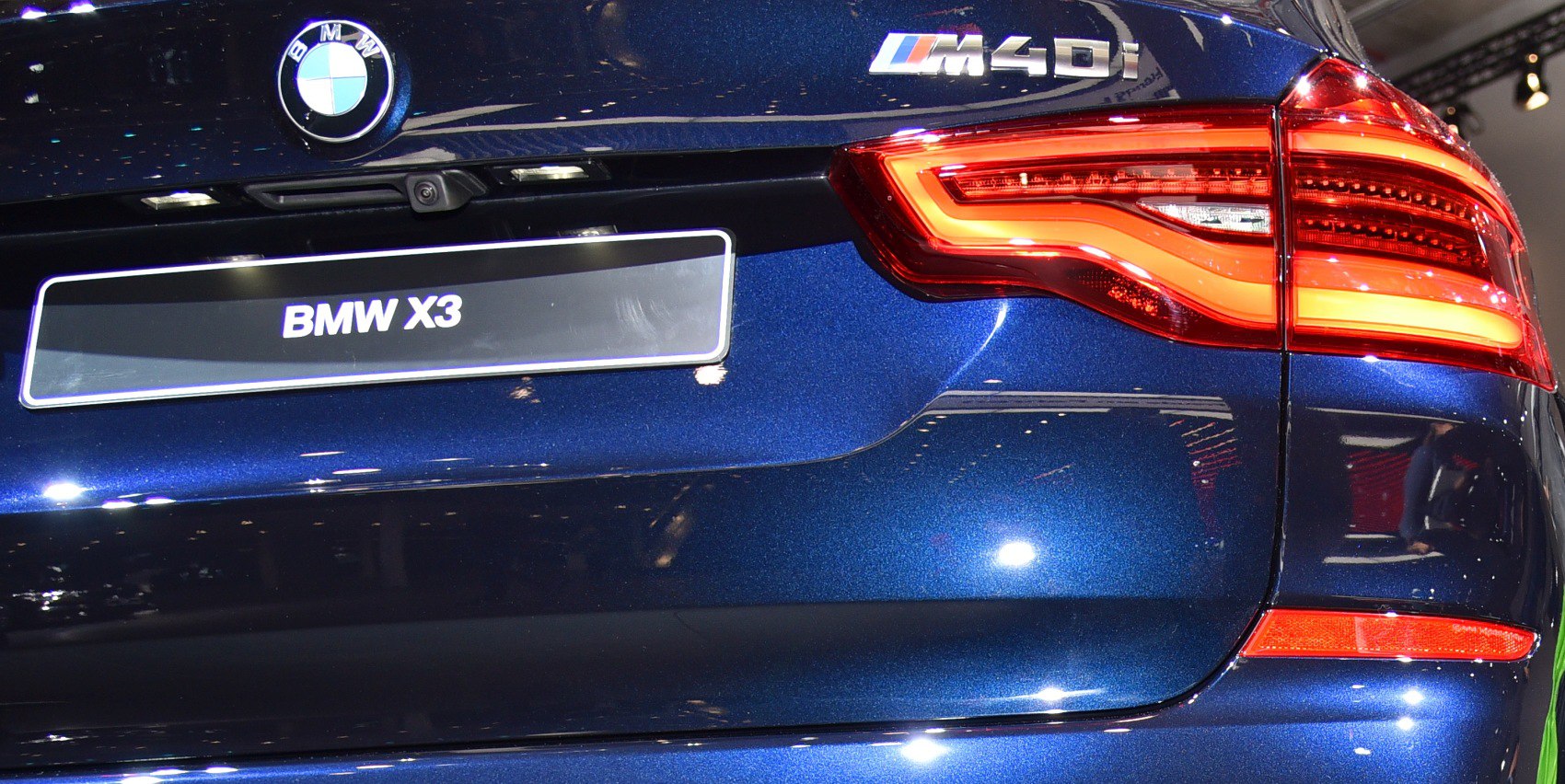 Close-up of BMW rear tail light and M40i badge on blue paint