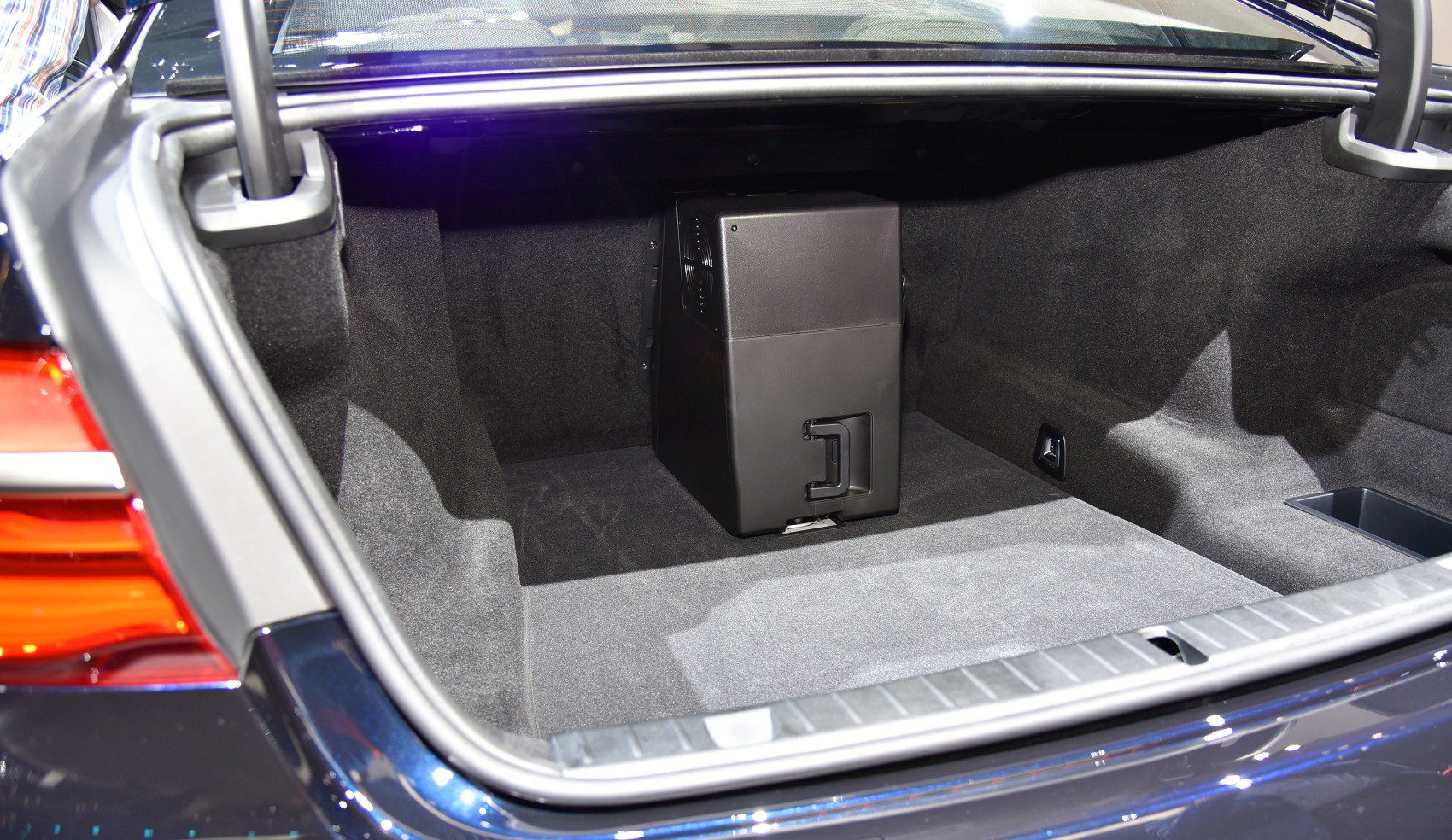Open trunk with a compact black storage unit inside