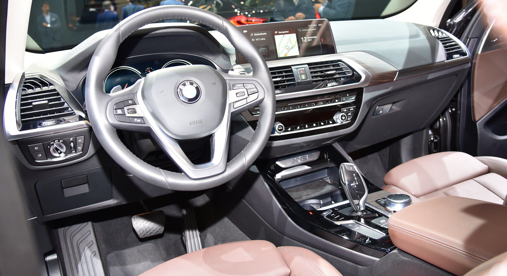 Luxury car interior with steering wheel, infotainment screen, and center console