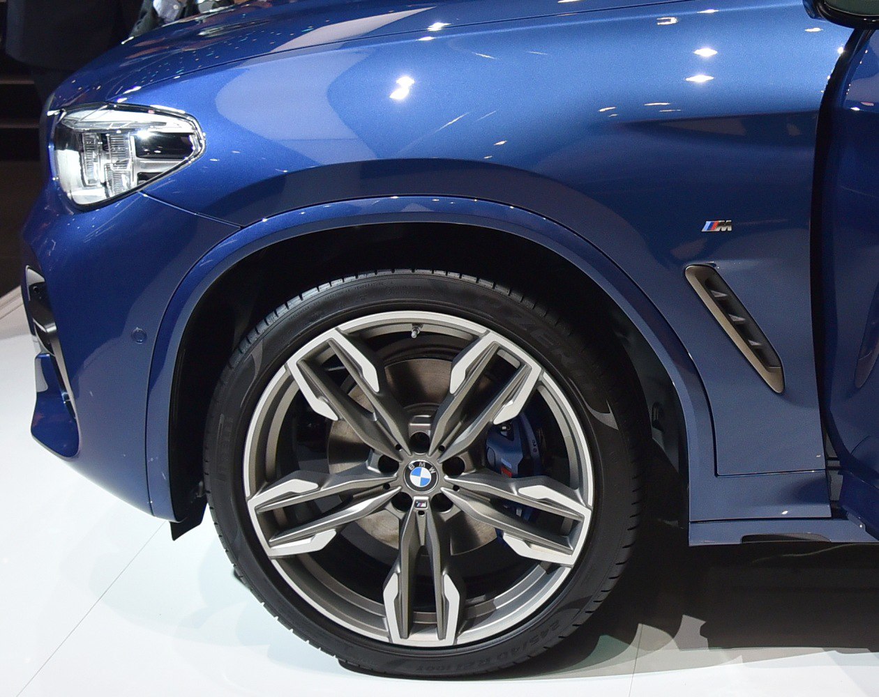 Close-up of front wheel, M badge, and headlight