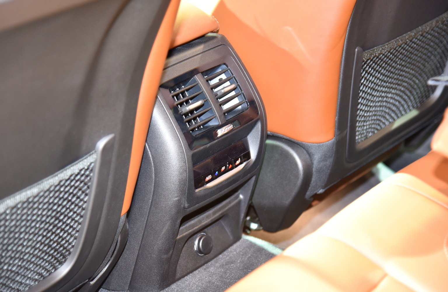 Rear seat climate control panel and air vents with brown leather interior