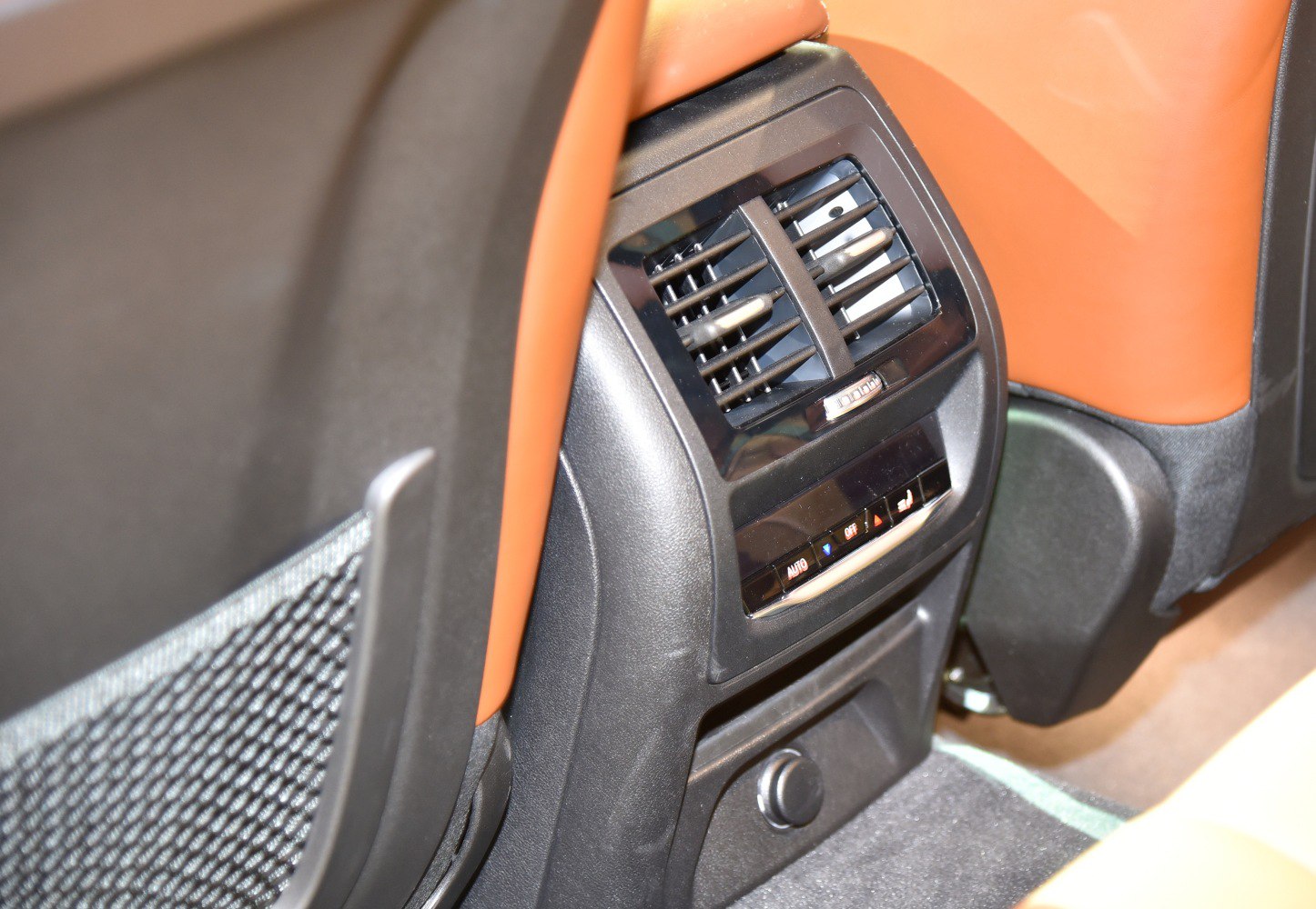 Rear passenger air vents and digital climate control panel with brown leather trim
