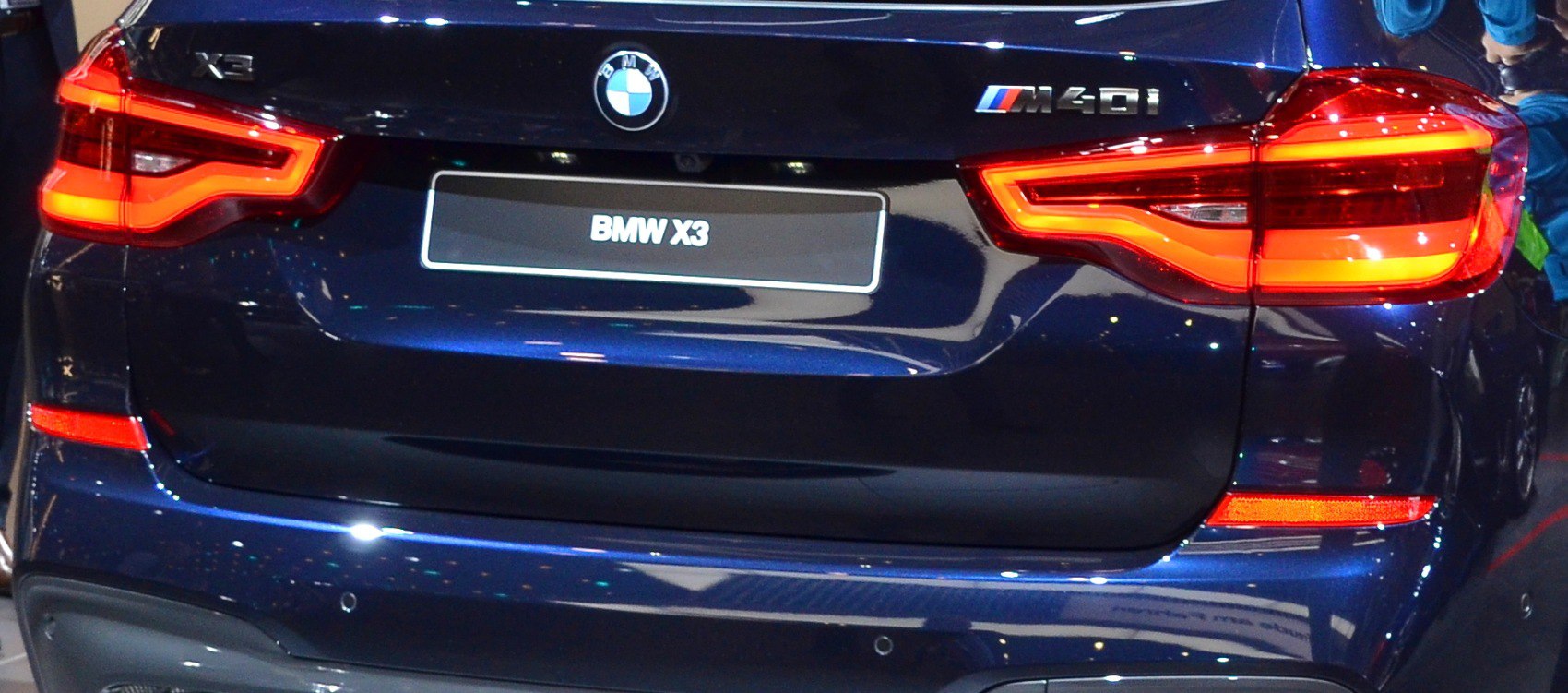 Rear tail light and M40i badge of dark-colored SUV