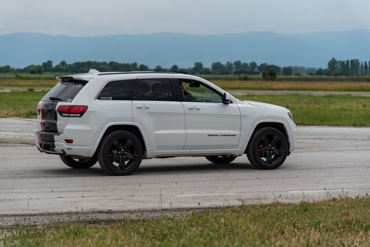 White SUV side profile with black wheels and rear spoiler