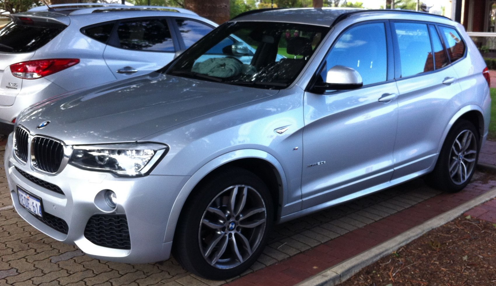 Silver SUV with distinct headlights and sporty alloy wheels, side front view