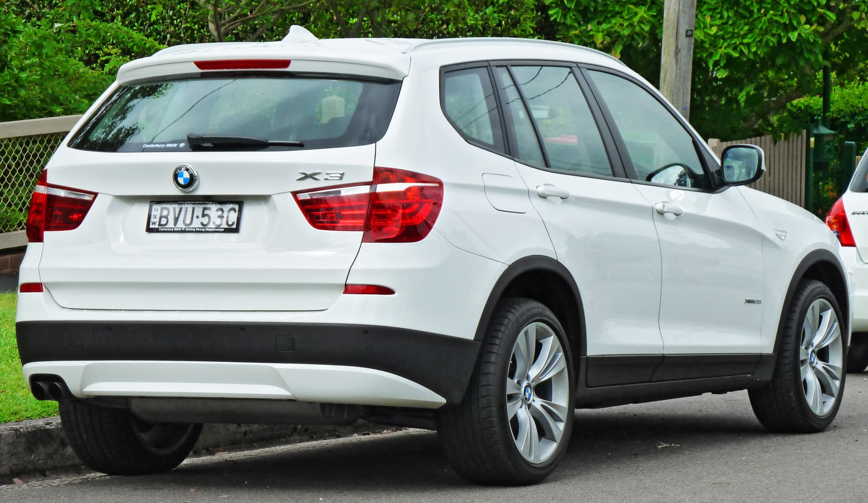 Rear view of white SUV with tail lights and alloy wheels