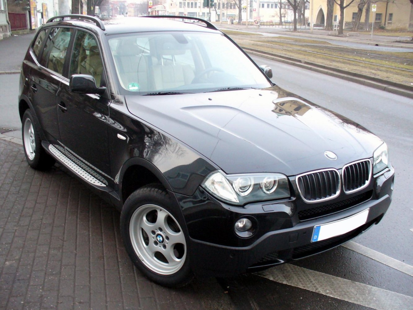 Front 3/4 view of black SUV with kidney grille and dual headlights
