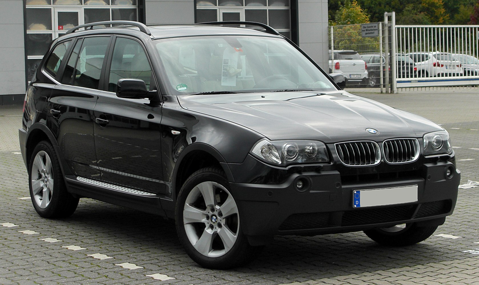 Front side view of black SUV with roof rails and alloy wheels
