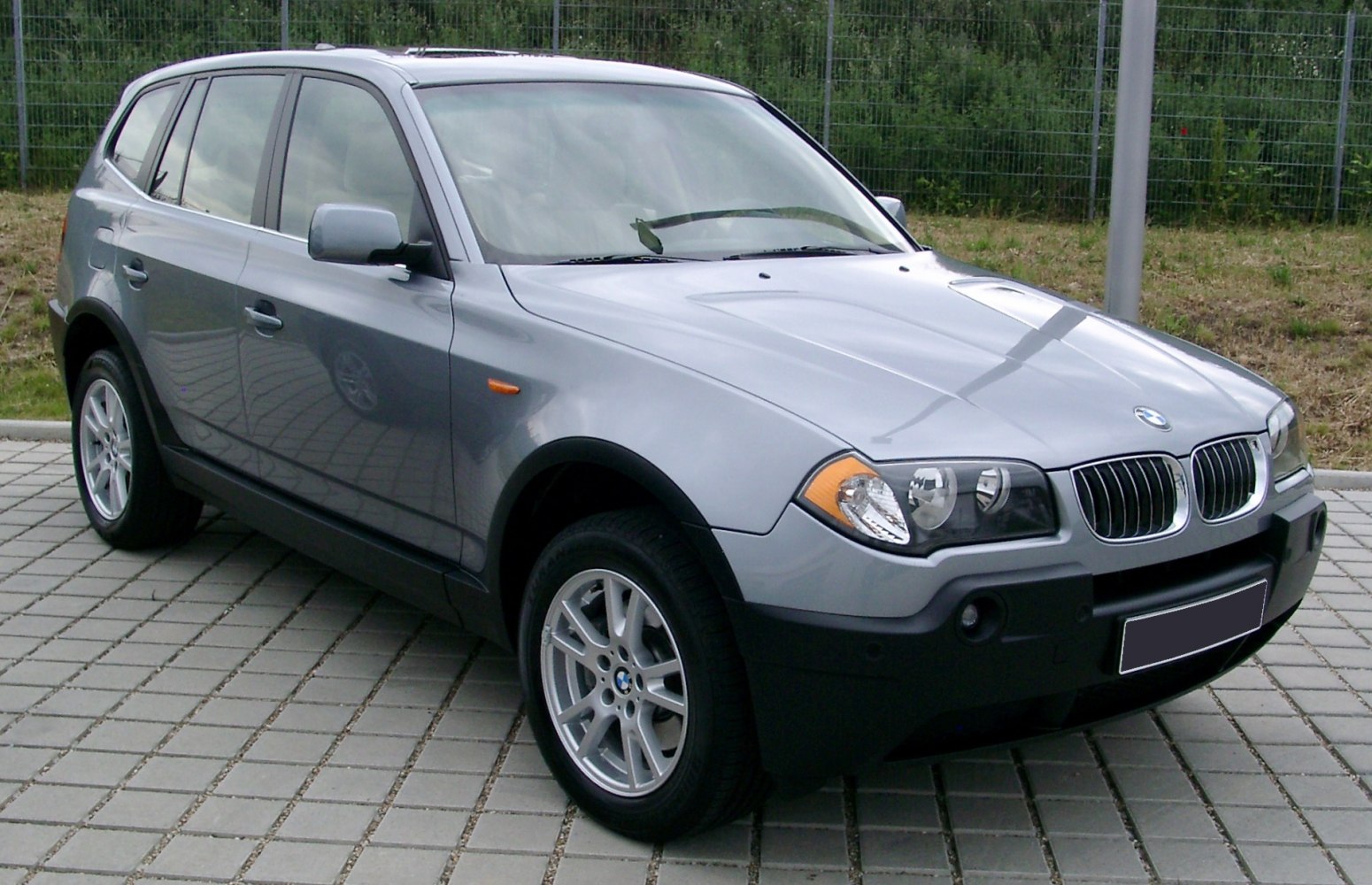 Front-side angle showing grill, headlights, alloy wheels, and robust bumper.