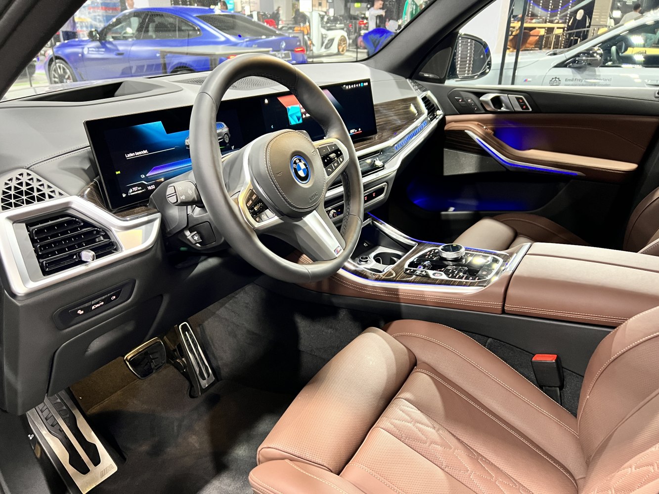 Luxurious interior with digital cockpit, ambient lighting, and brown leather seats