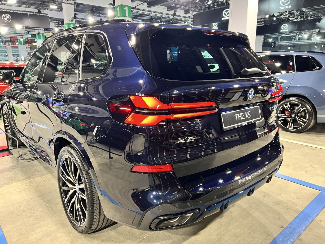 Rear view featuring LED tail lights, dual exhausts, dark blue paint, and sporty alloy wheels