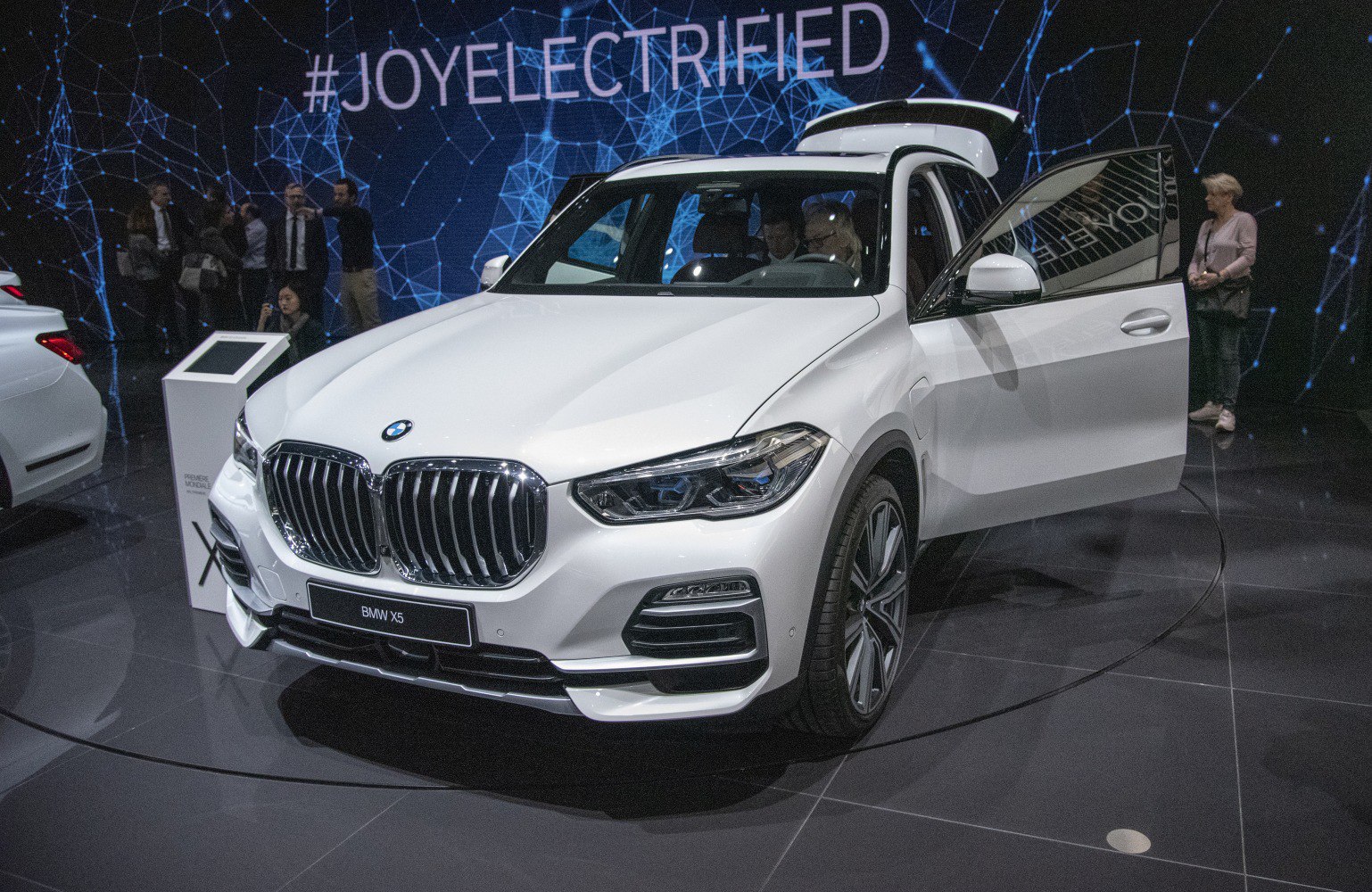 White SUV front with open passenger door and detailed lighting