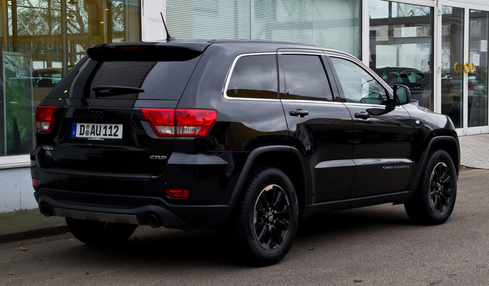 Rear and side view of black SUV with tinted windows and distinctive taillights