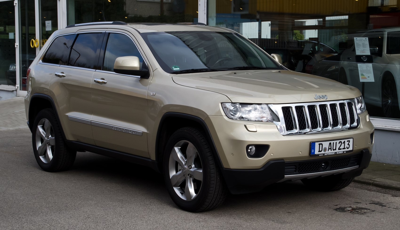 Front side view of an SUV with grille, alloy wheels, tinted windows