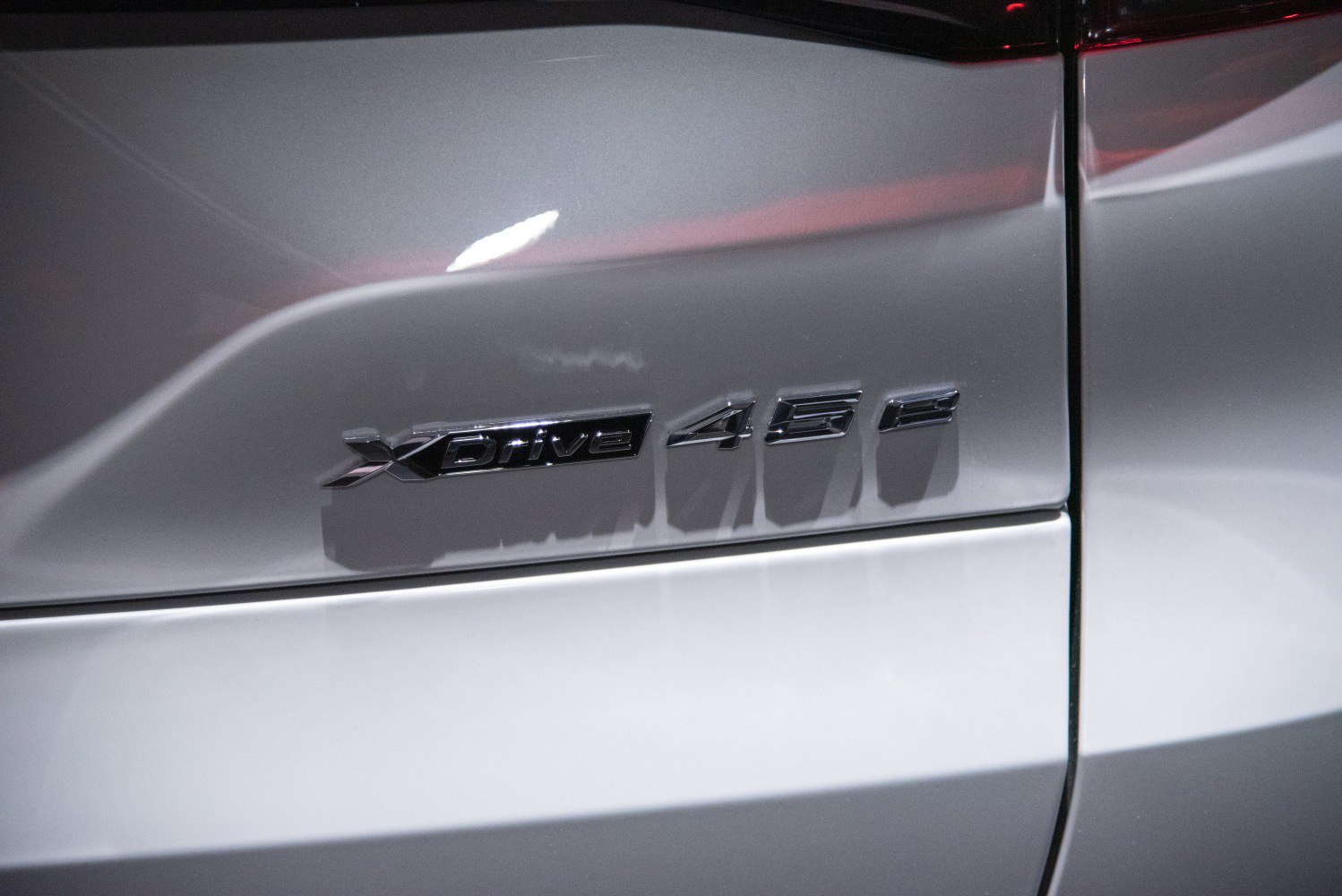 Close-up of BMW xDrive 45e badge on silver vehicle rear side panel
