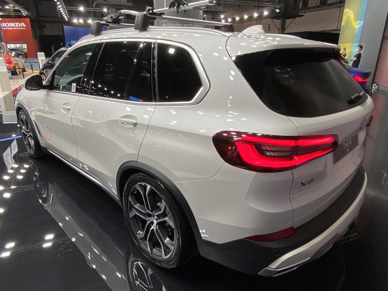 Side and rear exterior view of white SUV with roof rack and distinctive taillights