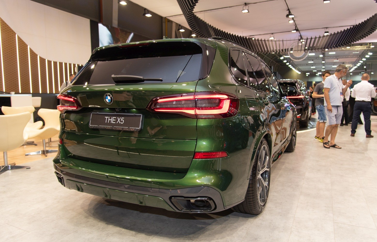 Rear view of a deep green SUV with prominent tail lights and sporty rear design
