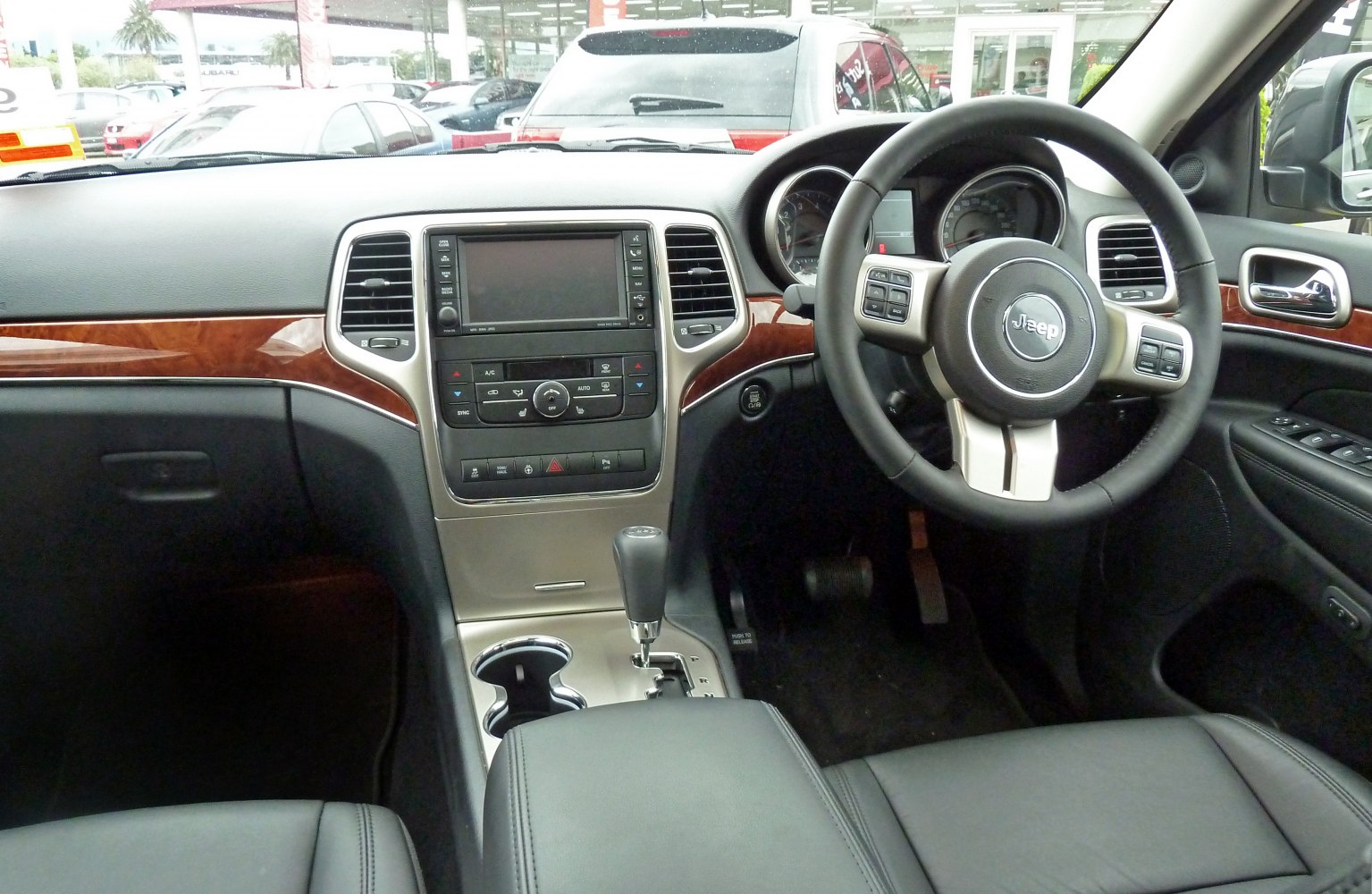 Dashboard with wood trim and multifunction steering wheel.