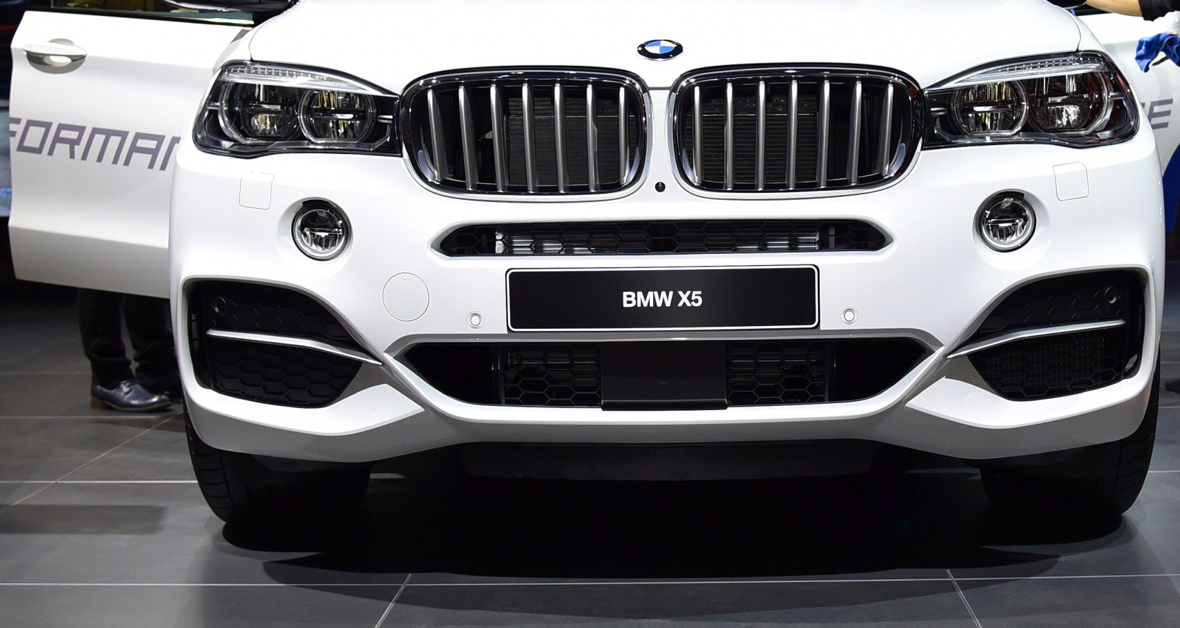 Close-up of front grille and dual headlights on a luxury SUV.
