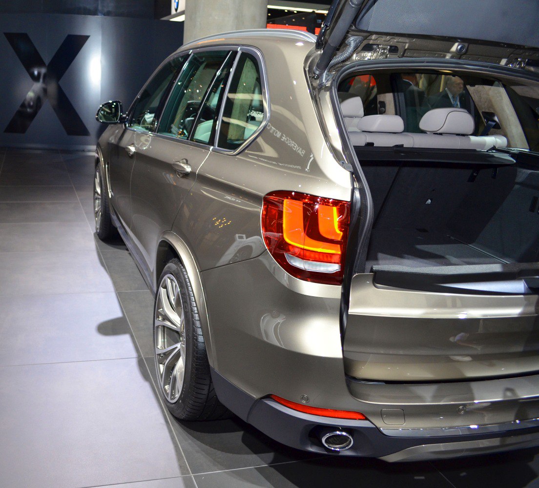 SUV rear side with open tailgate and illuminated taillights