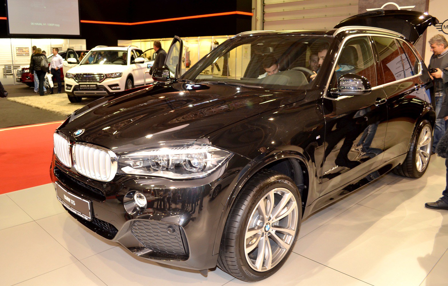 Front-side view of an SUV with open rear hatch and modern headlamps