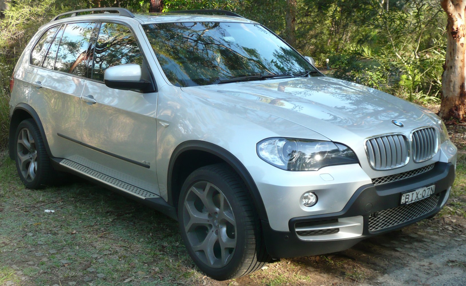 Front side view of silver SUV with alloy wheels and running board