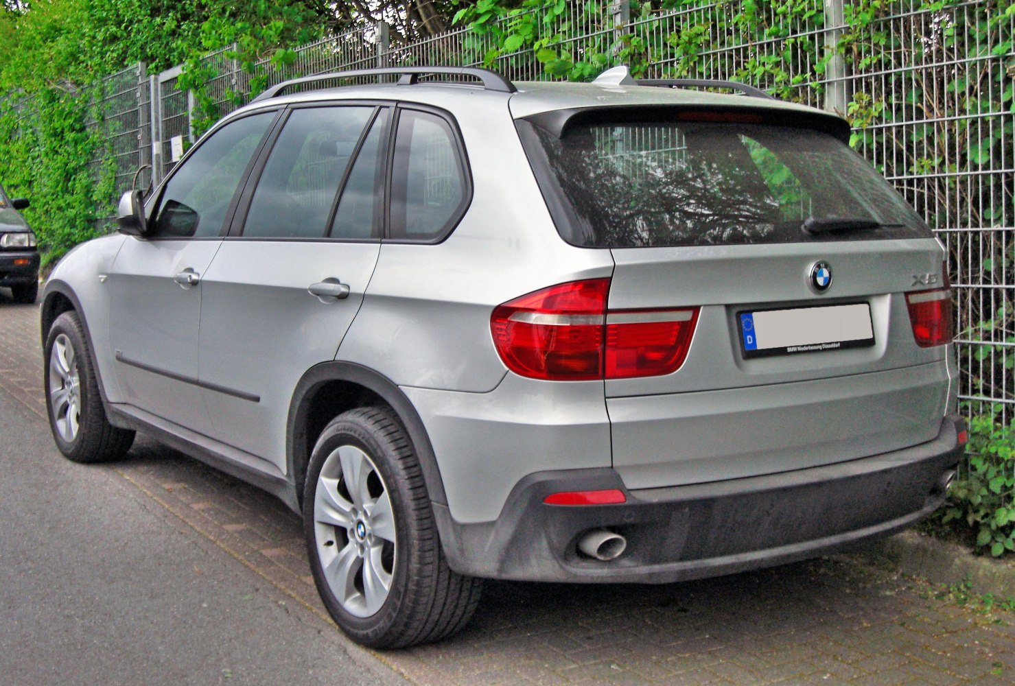 Silver SUV rear side with roof rails and distinctive tail lights