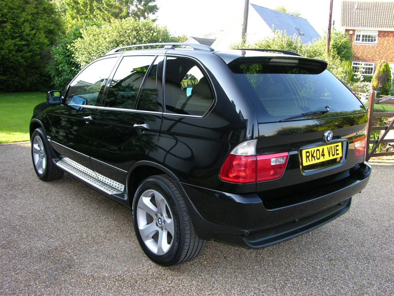 Black SUV rear side with alloy wheels, roof rails, and side running boards